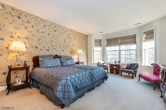 bedroom featuring wallpapered walls, carpet, visible vents, and baseboards