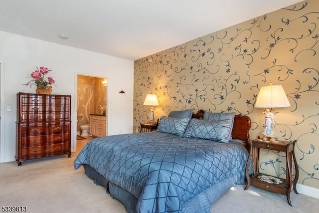 bedroom with ensuite bath, carpet, baseboards, and wallpapered walls