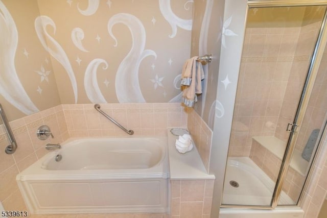 bathroom featuring a garden tub and a shower stall