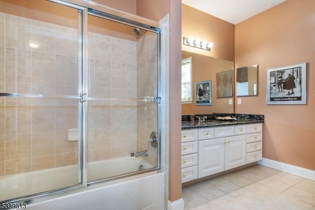 full bathroom with tile patterned floors, vanity, baseboards, and bath / shower combo with glass door