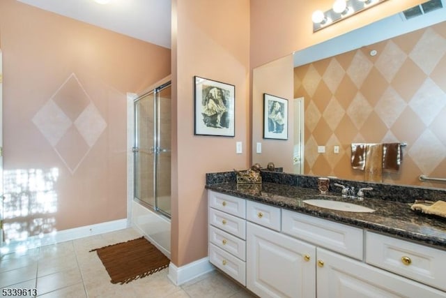 full bathroom featuring visible vents, combined bath / shower with glass door, vanity, tile patterned flooring, and baseboards