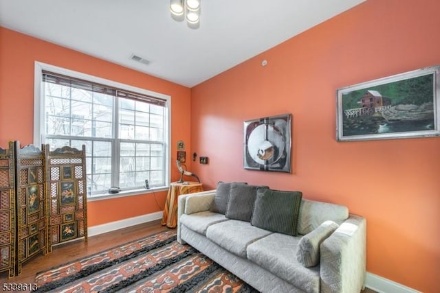 living room with visible vents, baseboards, and wood finished floors