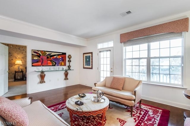 living room with visible vents, baseboards, dark wood finished floors, and crown molding