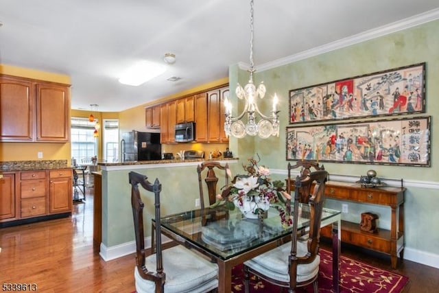 dining space with baseboards, a chandelier, dark wood-style flooring, and ornamental molding