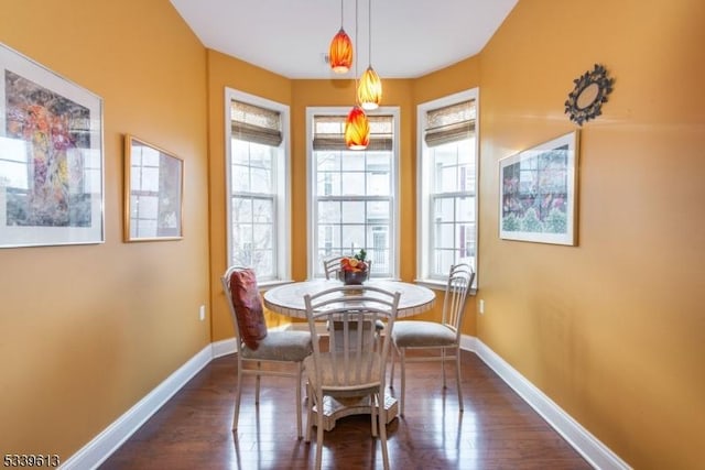 dining area featuring dark wood-type flooring and baseboards