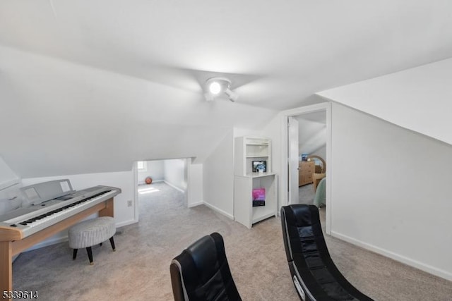 interior space with light carpet, vaulted ceiling, and baseboards