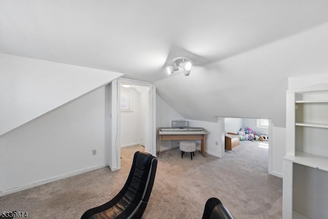 interior space with light carpet, lofted ceiling, a wealth of natural light, and baseboards