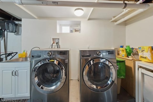 clothes washing area with cabinet space and washer and clothes dryer