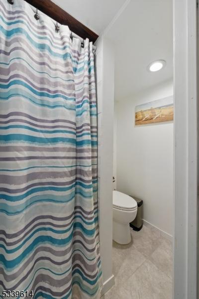 full bathroom featuring tile patterned flooring and toilet