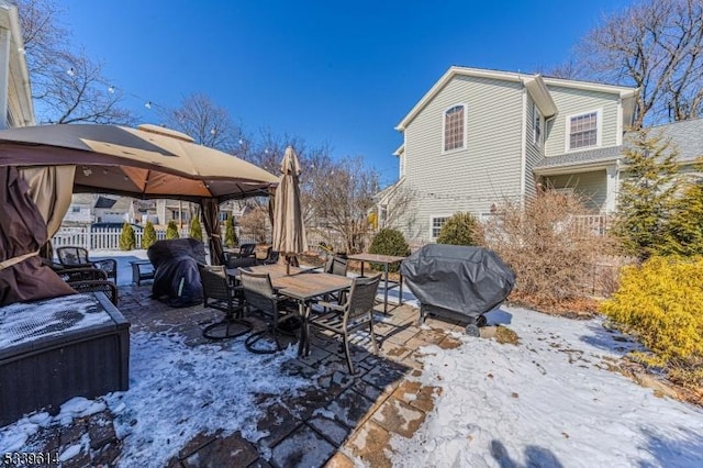 yard layered in snow with fence and a gazebo