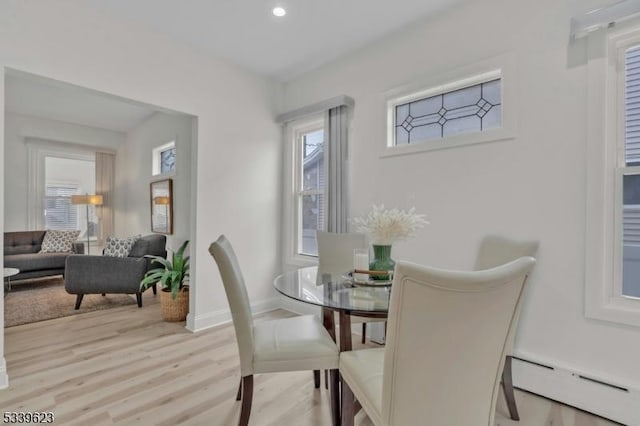 dining area featuring a baseboard radiator, light wood-style flooring, baseboards, and recessed lighting