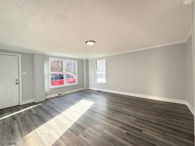 unfurnished room featuring baseboards, dark wood-type flooring, a textured ceiling, and crown molding