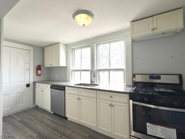 kitchen featuring dark wood-style floors, appliances with stainless steel finishes, white cabinets, and a sink