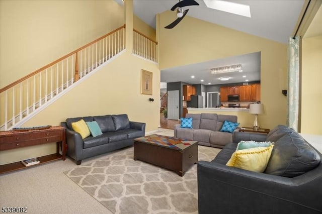 living room with a skylight, recessed lighting, light colored carpet, stairway, and high vaulted ceiling