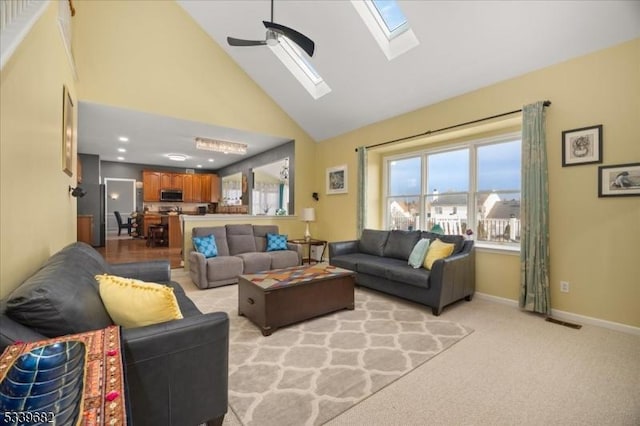 living area featuring high vaulted ceiling, light colored carpet, a ceiling fan, baseboards, and visible vents