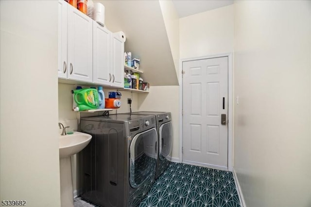 washroom with independent washer and dryer, cabinet space, and baseboards