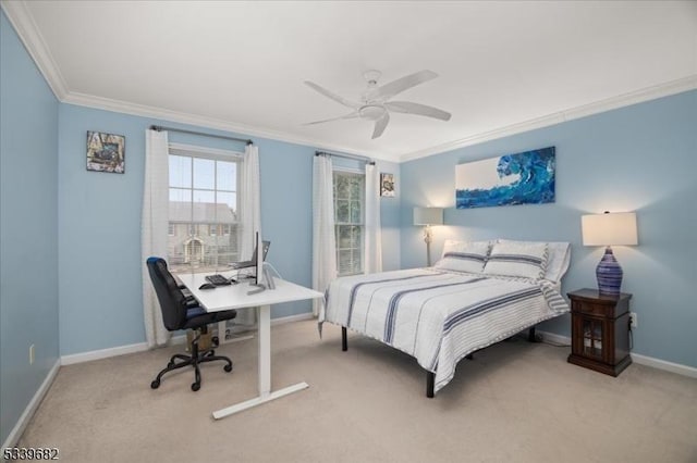 carpeted bedroom with crown molding, baseboards, and ceiling fan