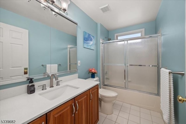 bathroom with bath / shower combo with glass door, visible vents, toilet, vanity, and tile patterned floors