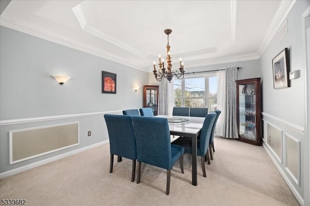 dining room with visible vents, a tray ceiling, ornamental molding, and light colored carpet