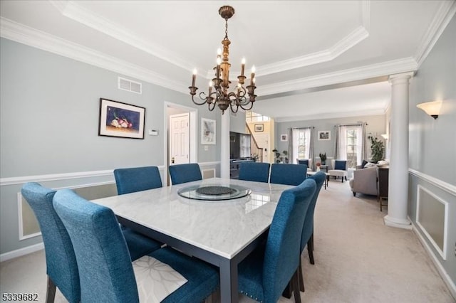 dining room with light carpet, a tray ceiling, visible vents, and ornate columns