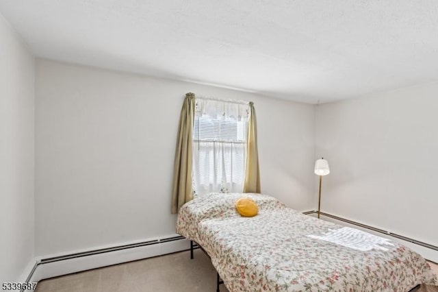 carpeted bedroom with a baseboard heating unit