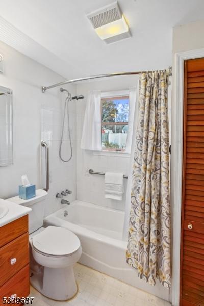 full bath with toilet, shower / bath combo, visible vents, and vanity