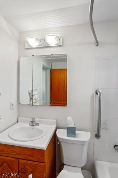 bathroom featuring shower / tub combination, vanity, and toilet