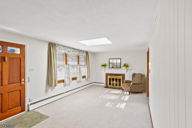 living area featuring a skylight, a brick fireplace, baseboard heating, and carpet flooring