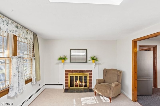 living area with a baseboard heating unit, carpet, baseboards, and a brick fireplace