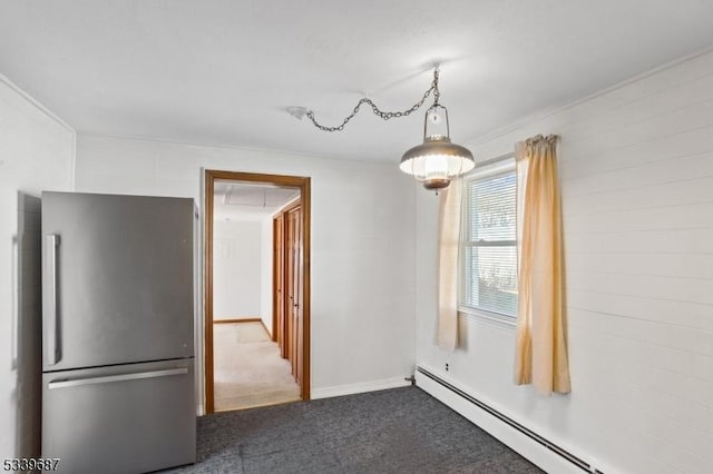 unfurnished dining area with attic access, dark carpet, baseboard heating, and baseboards