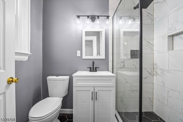 full bathroom featuring baseboards, toilet, vanity, and a shower stall