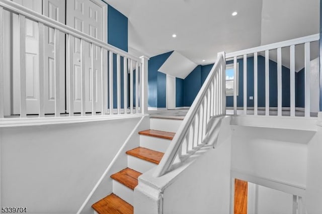 staircase with lofted ceiling and recessed lighting