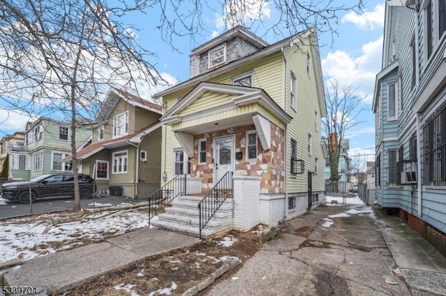 traditional style home with a residential view, fence, and cooling unit