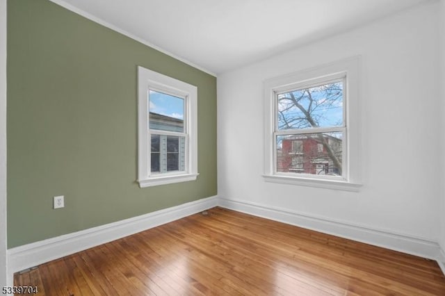 empty room with baseboards and wood finished floors