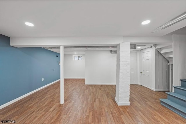 below grade area with recessed lighting, stairway, baseboards, and wood finished floors