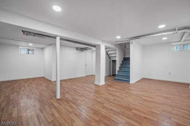 below grade area with stairway, recessed lighting, light wood-style flooring, and baseboards