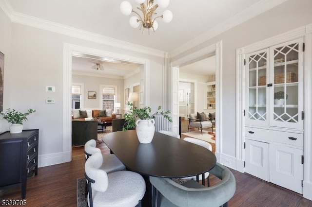 dining space with dark wood-style floors, ornamental molding, baseboards, and an inviting chandelier