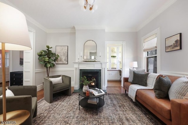 living room with a fireplace with flush hearth, baseboards, wood finished floors, and crown molding