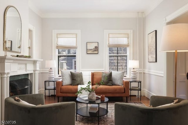 living area featuring a fireplace, wood finished floors, and crown molding