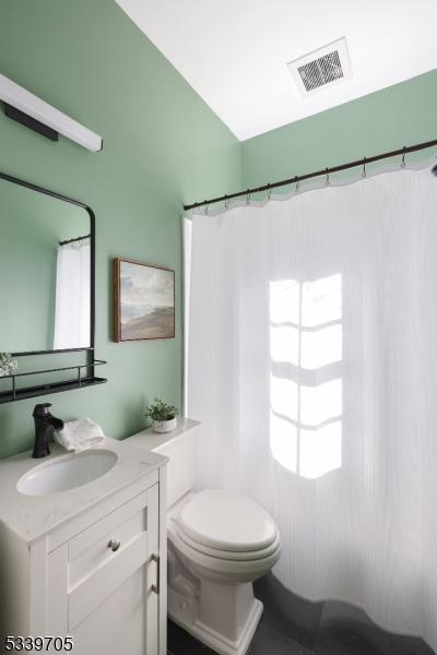 bathroom featuring toilet, visible vents, and vanity