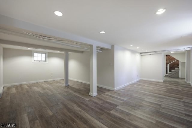 basement featuring dark wood-style floors, stairs, baseboards, and recessed lighting