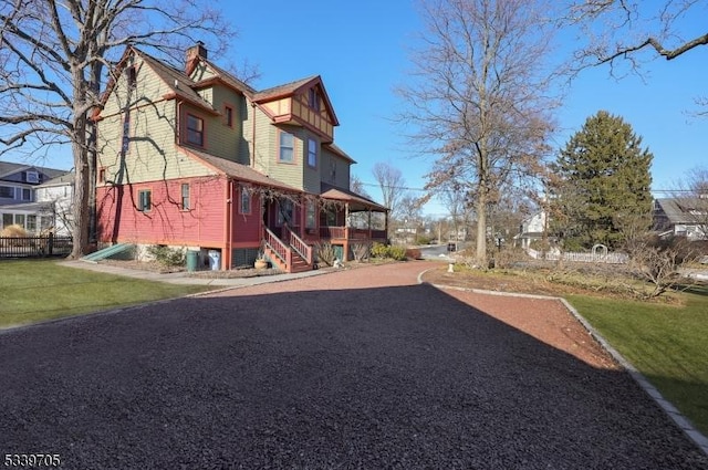 exterior space featuring a residential view, a chimney, and a lawn