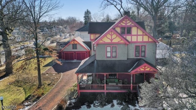 back of house with a detached garage and a porch