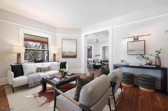 living room featuring a chandelier, wood finished floors, and baseboards