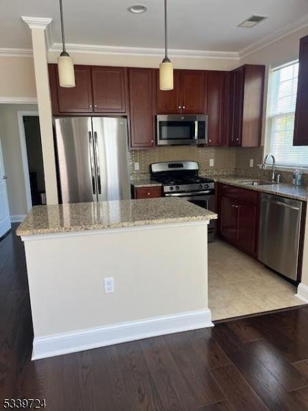 5107 Sanctuary Blvd Unit 5107, Riverdale Boro, NJ 07457 - kitchen with appliances with stainless steel finishes, ornamental molding, light stone counters, hanging light fixtures, and tasteful backsplash