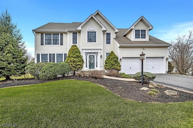 view of front of home featuring a garage, a front yard, and driveway