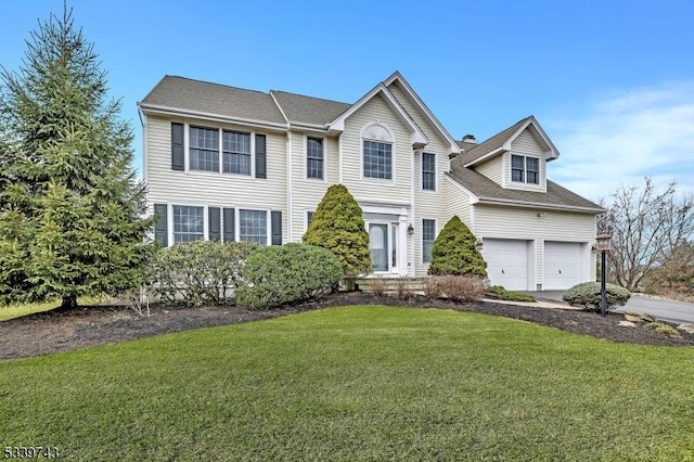 view of front of house with driveway, a garage, and a front lawn