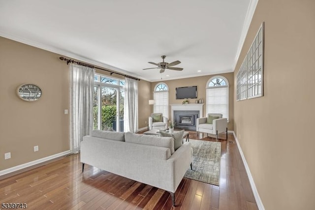 living room featuring a healthy amount of sunlight, crown molding, and wood finished floors