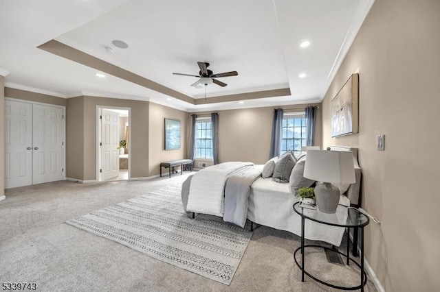 carpeted bedroom featuring ornamental molding, a tray ceiling, baseboards, and recessed lighting