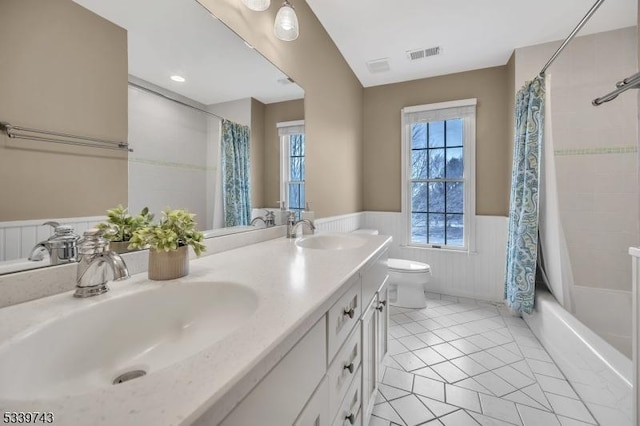 full bath featuring toilet, a wainscoted wall, visible vents, and a sink